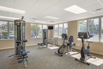 Bright fitness room with large windows and exercise bikes